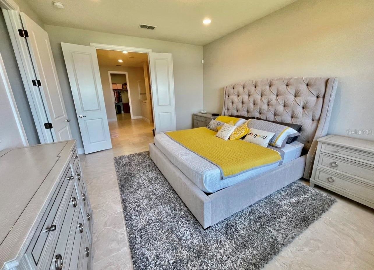 master bedroom with yellow and grey sheets on the bed